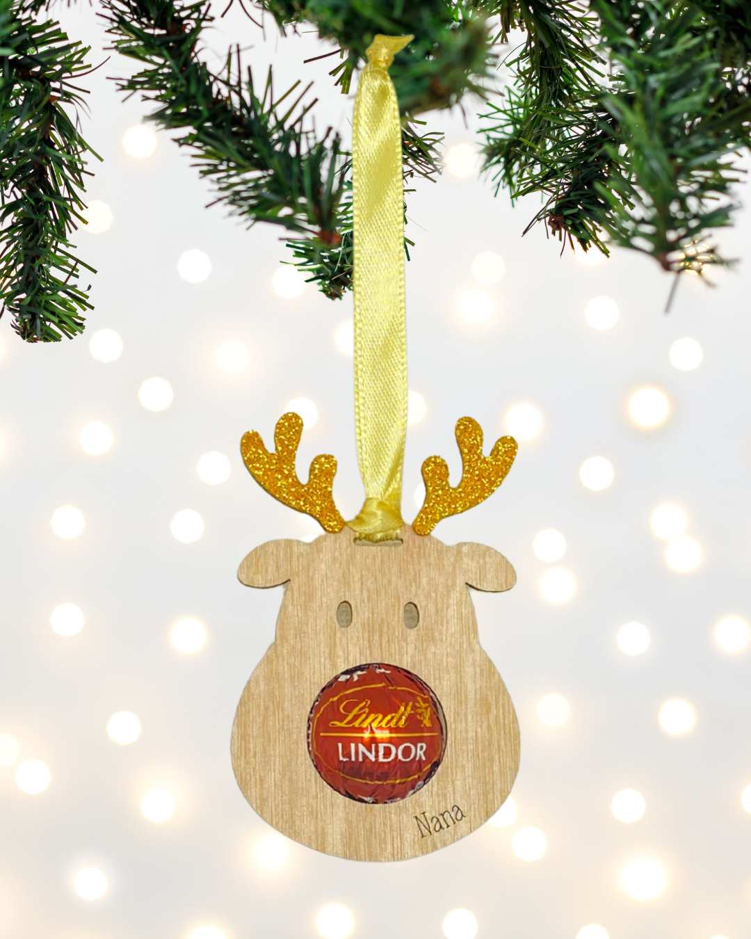 Laser-cut wooden Sweet-Nose Reindeer Ornament in gold with a Lindt chocolate nose, engraved with the word  Nana.