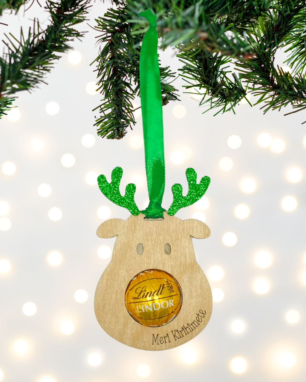 Laser-cut wooden Sweet-Nose Reindeer Ornament in greenwith a Lindt chocolate nose, engraved with the words Meri Kirihimete.
