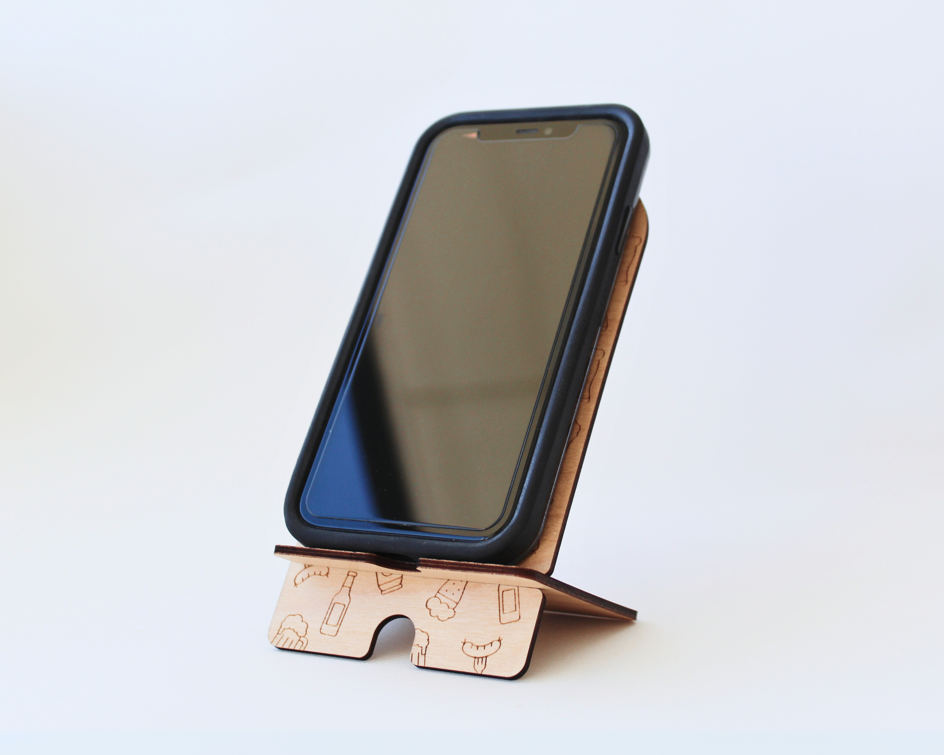 Wooden Phone Stand in the Beer & Sausages design against a white background, holding a cellphone in portrait mode.