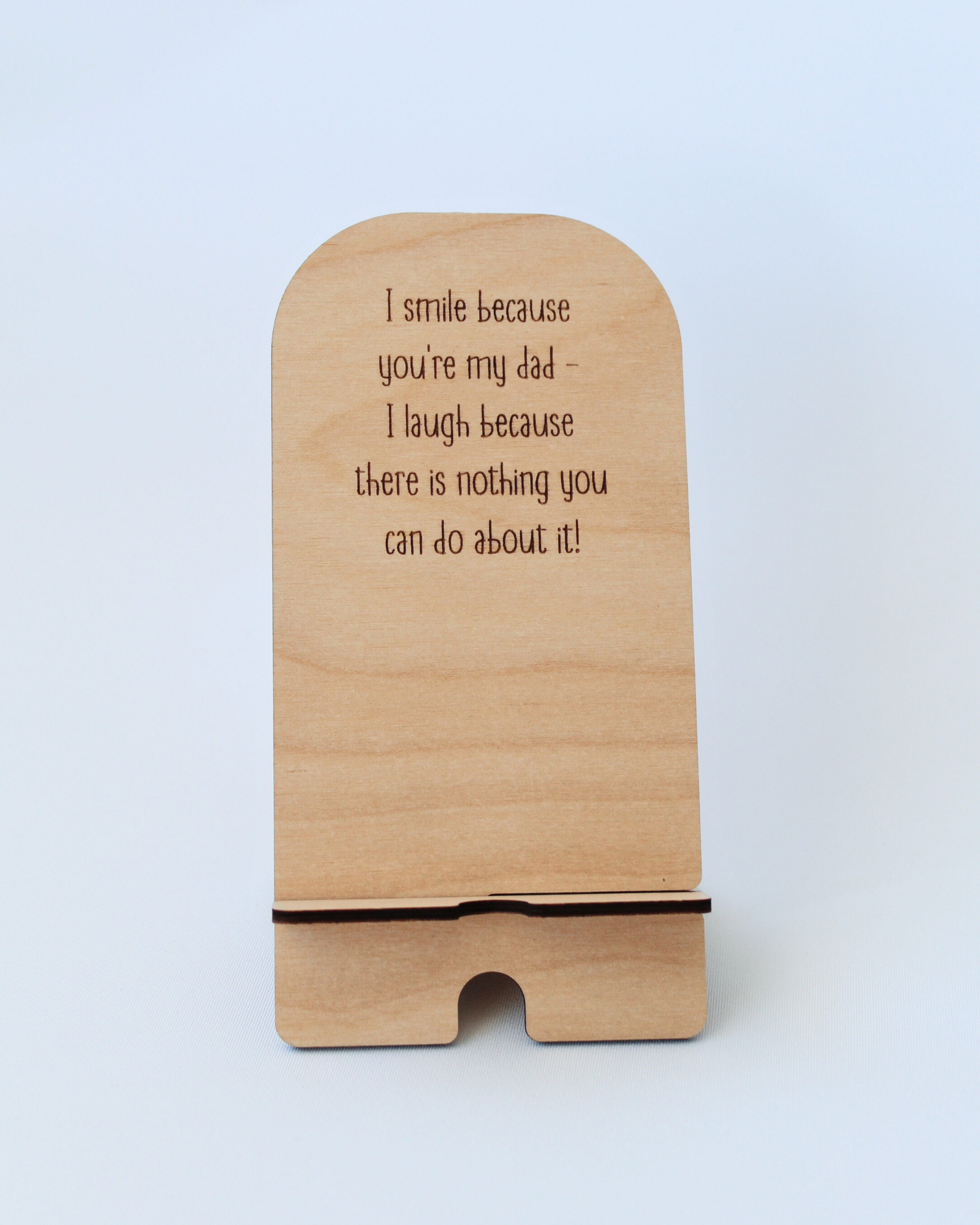 Wooden Phone Stand in the Smile design against a white background, holding a cellphone in landscape mode.